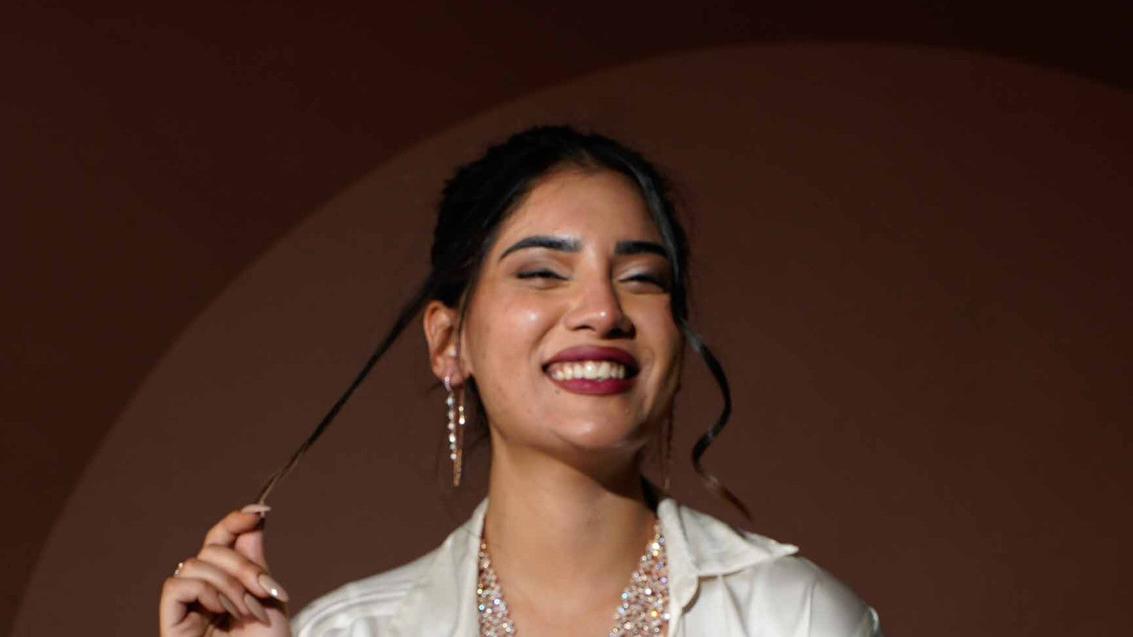 Woman laughing in diamond earrings and a layered diamond necklace
