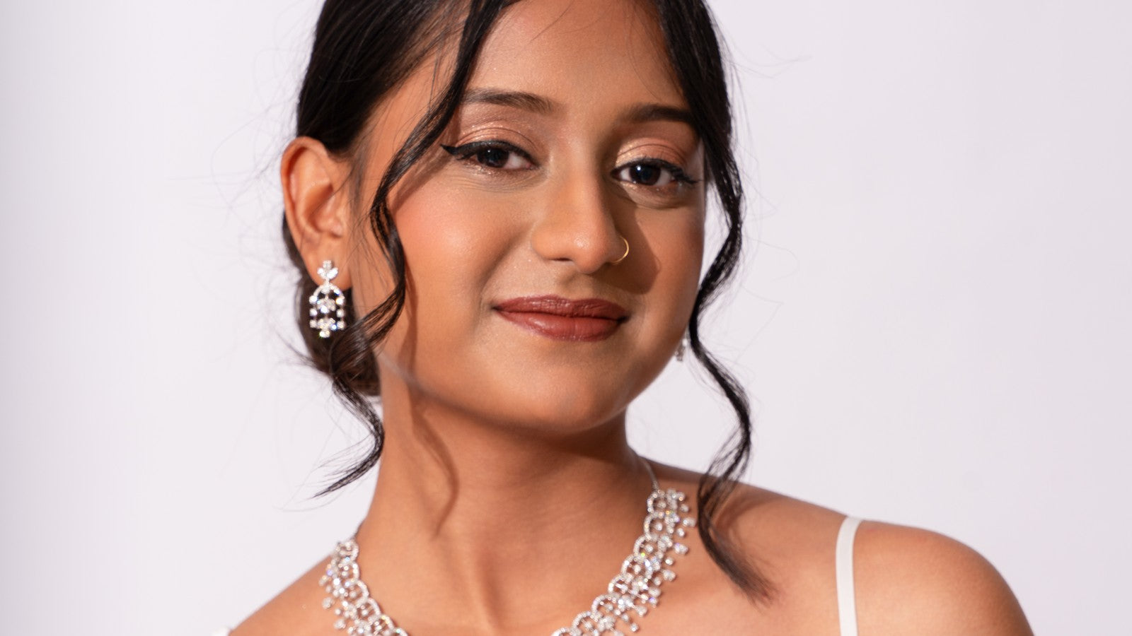 Smiling bride in diamond drop earrings and a diamond necklace