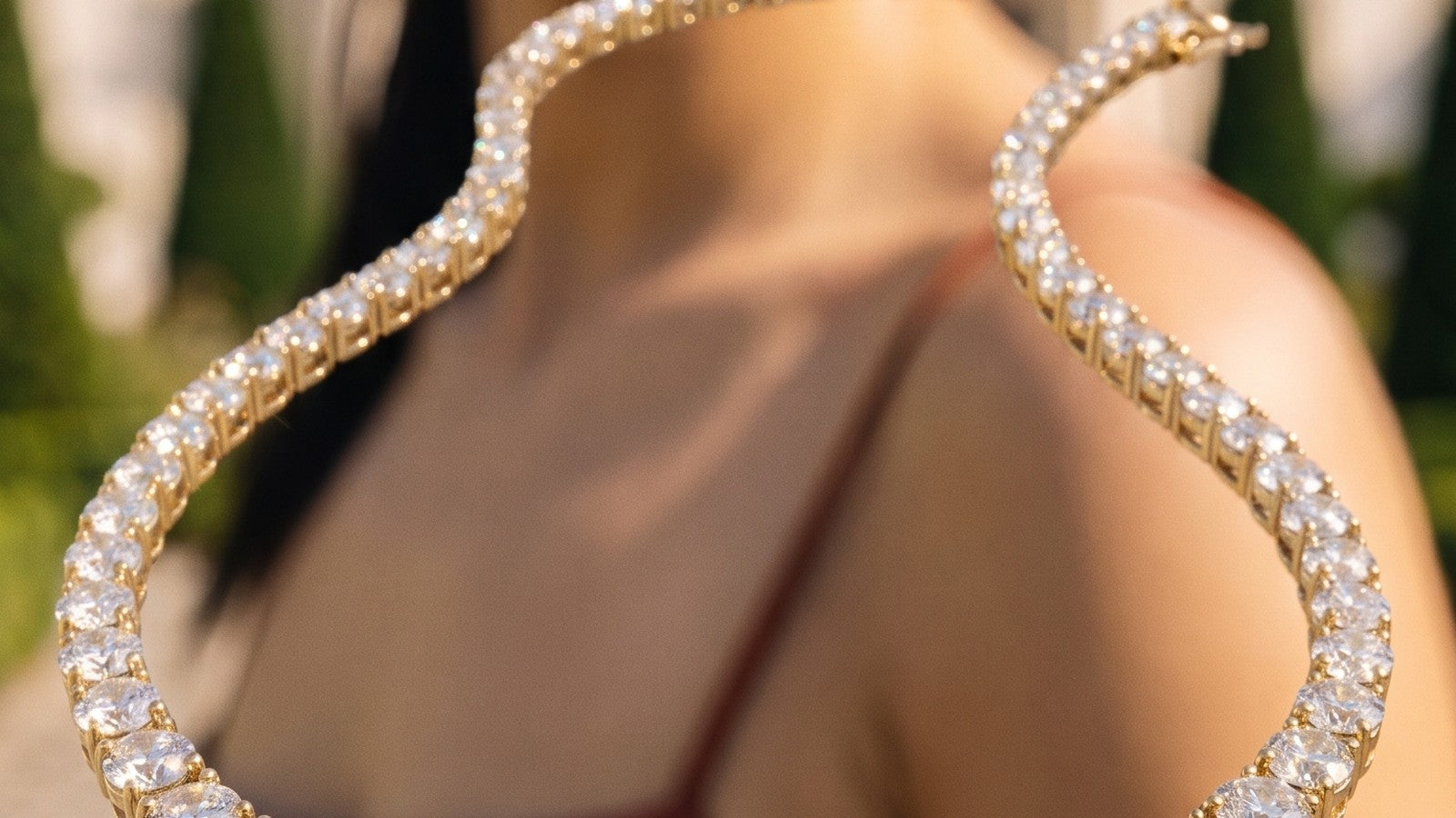 A graduated diamond necklace catching the light against bare shoulders