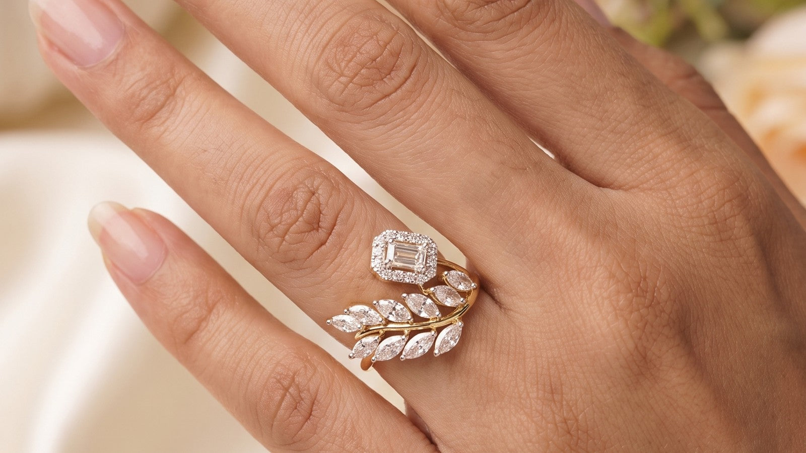 A diamond leaf ring worn on a woman's hand