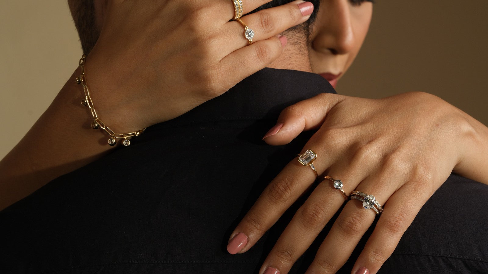 Wife embracing her husband, diamond rings and a gold bracelet on her hands