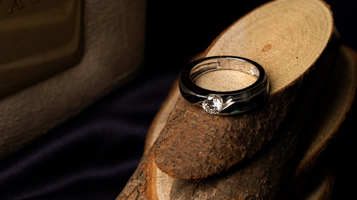 Men's diamond ring with a black band and a single round diamond
